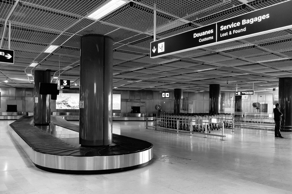 Un voyageur avec un bagage à l'aéroport sur le bande-transport