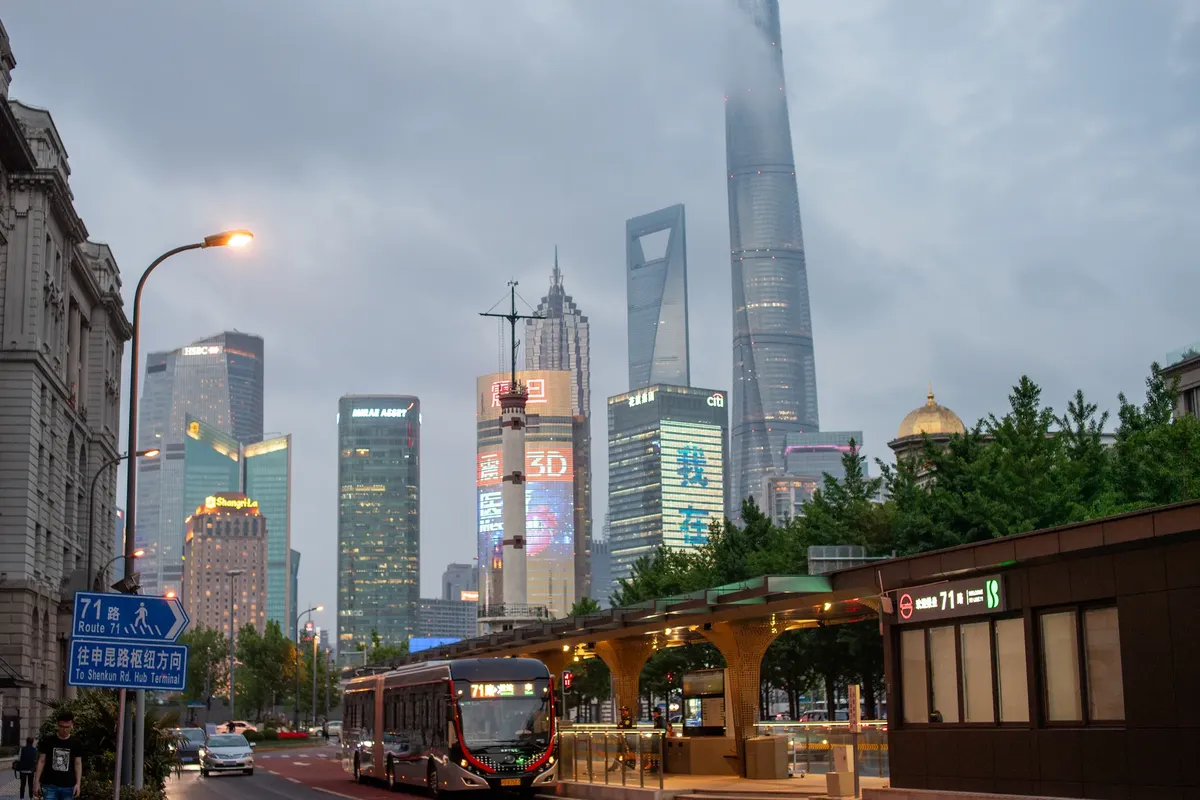 A bustling evening scene of Shanghai's skyline featuring the iconic skyscrapers and urban transit in Pudong.