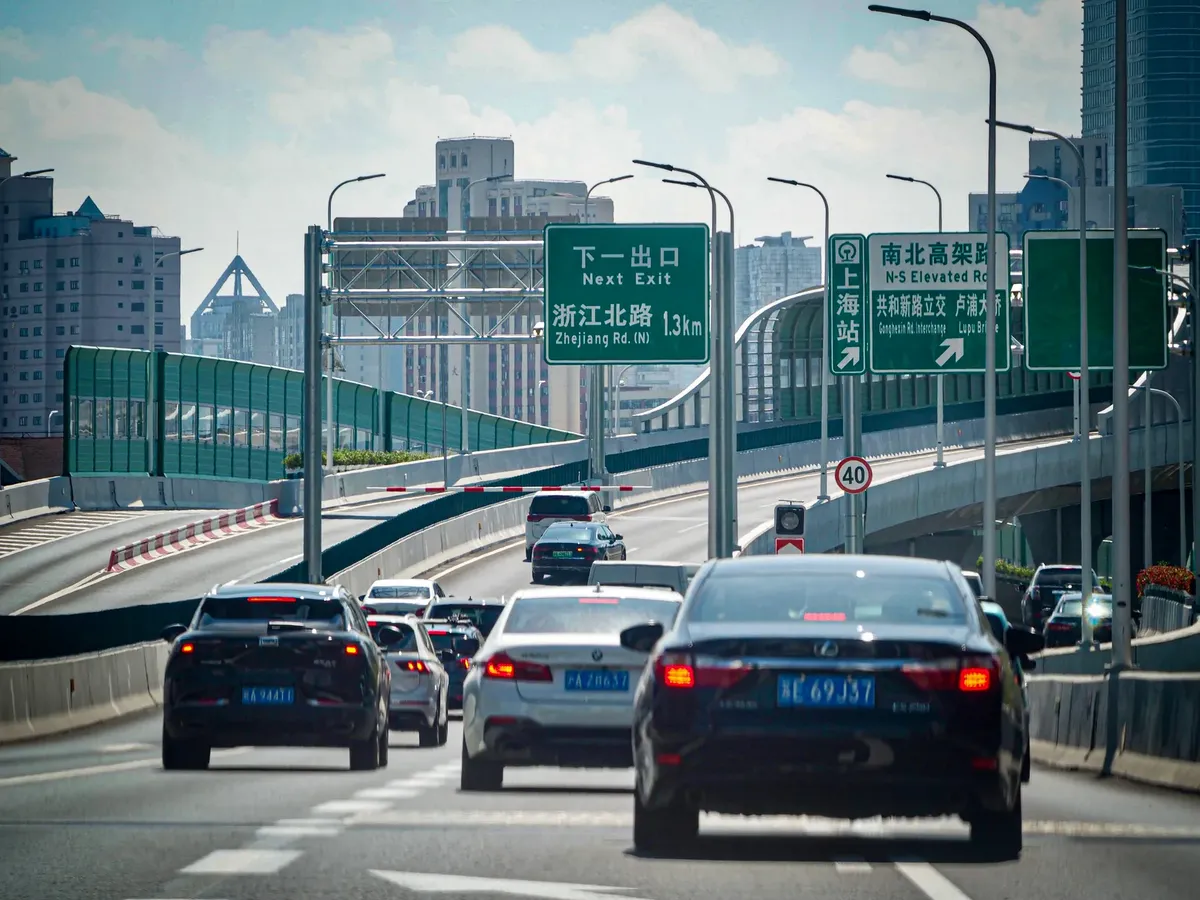 汽車在高架公路上穿行於上海的都市風景中。